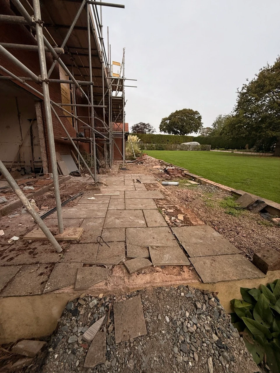 The original terrace against the house, with cracked and lifting paving.