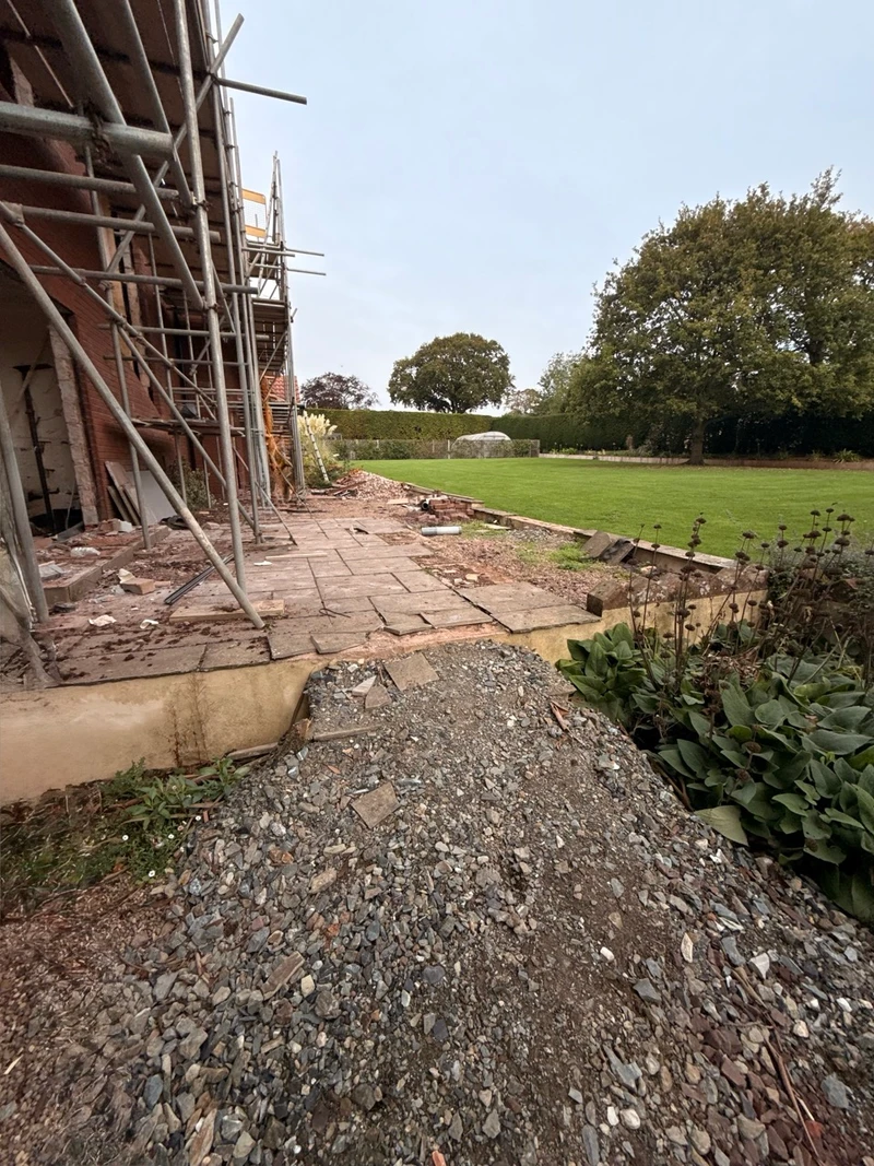 Looking along the house, showing the failed paving and the lawn beyond.